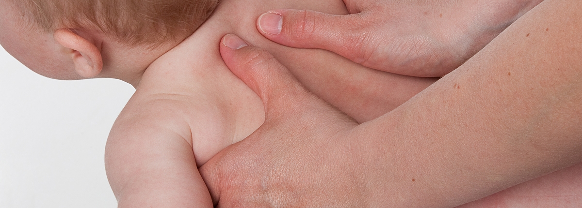 Baby kiropraktor undersøger babys ryg